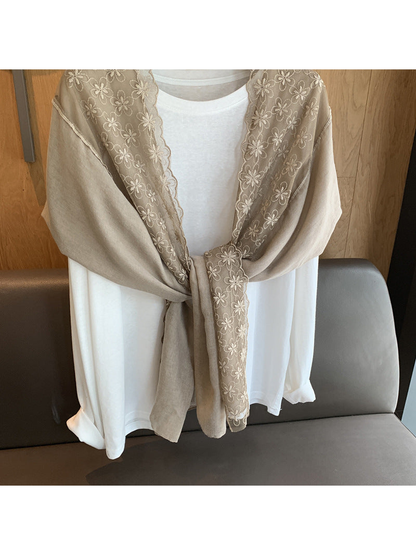 Close-up of the Greige scarf's floral border and knotted drape