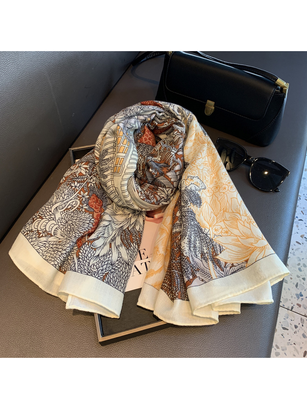 Multicolor botanical-print square scarf loosely rolled on a bench