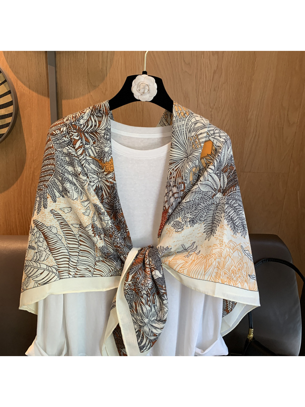 Close-up of the botanical line-art print and knotted scarf styling