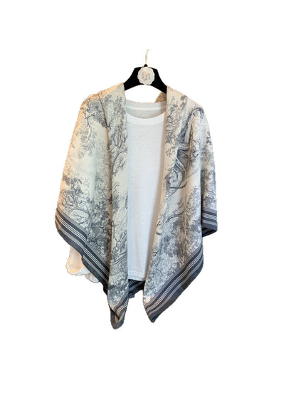 Ivory and gray-blue illustrated square scarf draped over a white top