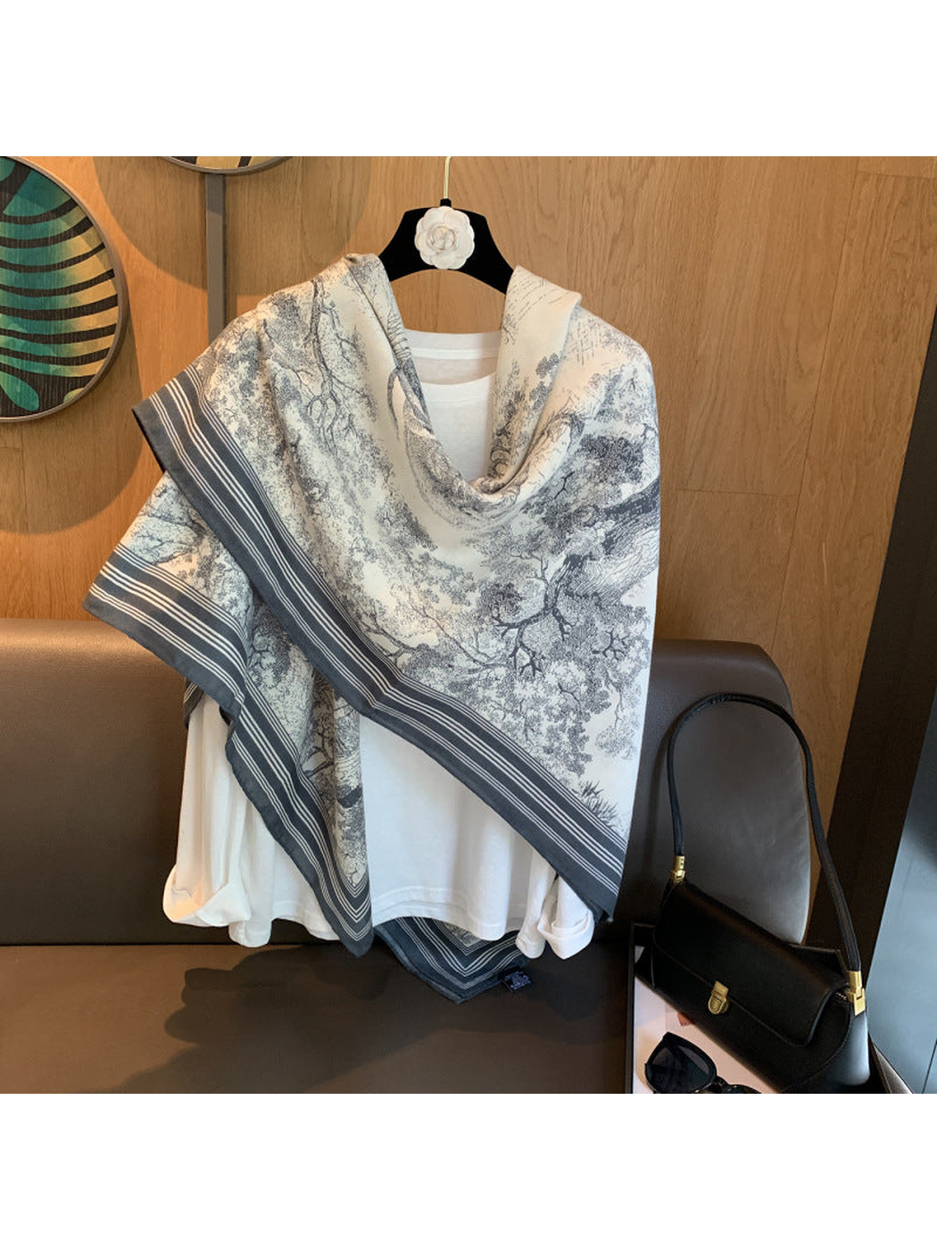 Ivory and gray-blue illustrated scarf draped diagonally over a white top