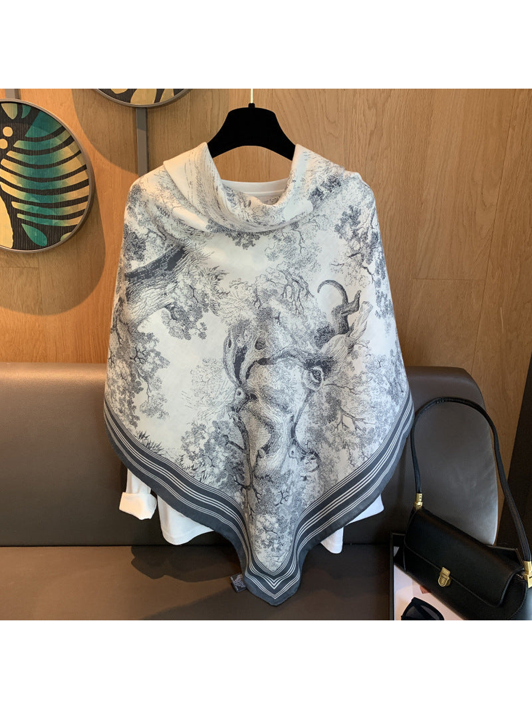 Ivory square scarf styled across the shoulders with a gray-blue striped border