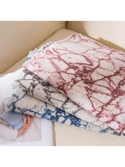 Burgundy, Black Gray and Blue abstract-print scarves stacked on a chair