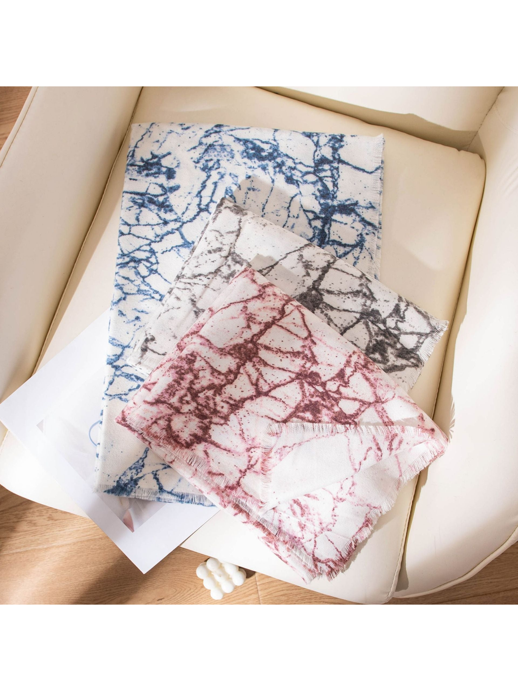 Burgundy, Black Gray and Blue abstract-print scarves arranged with fringed edges visible