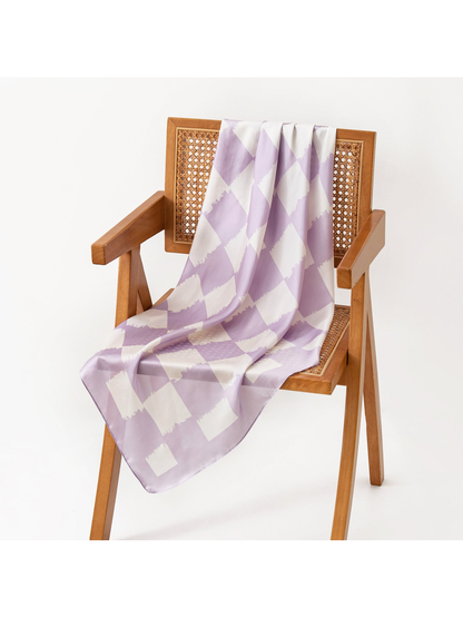 Light purple and ivory checkerboard square scarf draped over a wooden chair
