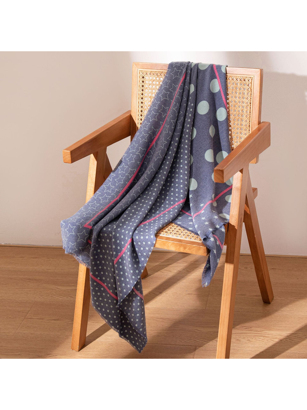 Navy scarf with mint dots and stars draped over a wooden chair