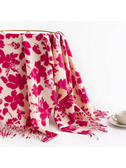 Pink and cream floral scarf draped over a rail beside a teacup