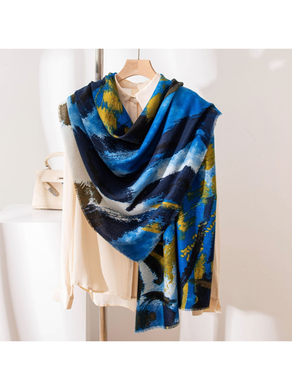 Blue abstract brushstroke scarf draped over a cream blouse on a hanger