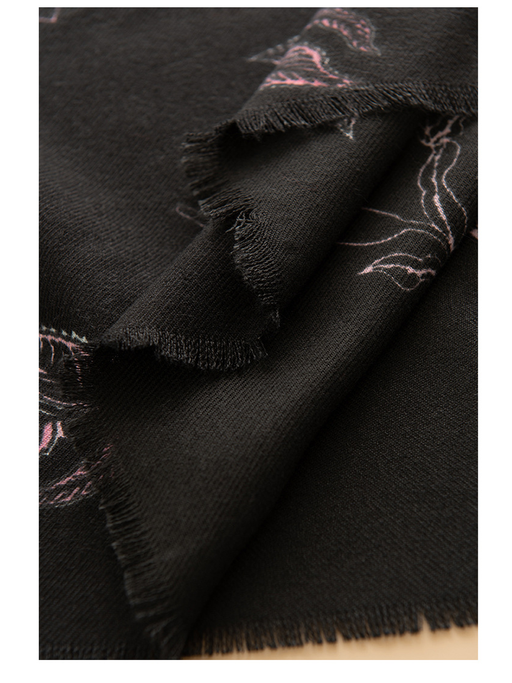 Close-up of layered black scarf edges and floral pattern