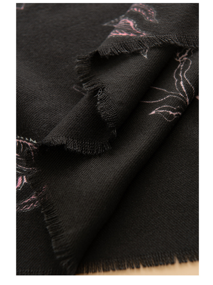 Close-up of layered black scarf edges and floral pattern