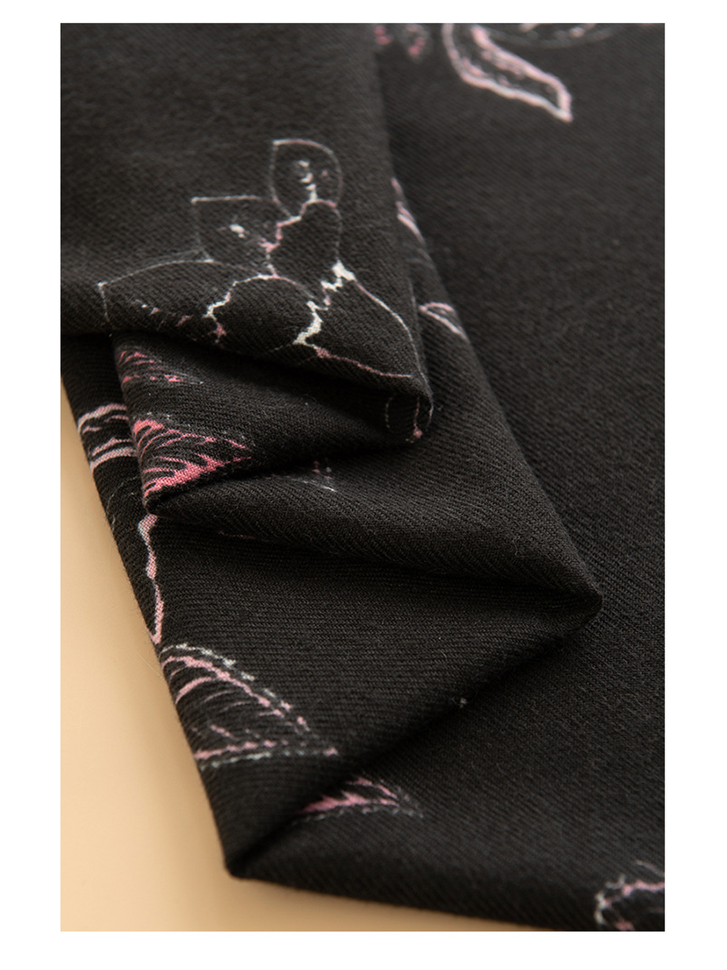 Close-up of the black scarf folds and pink floral motif