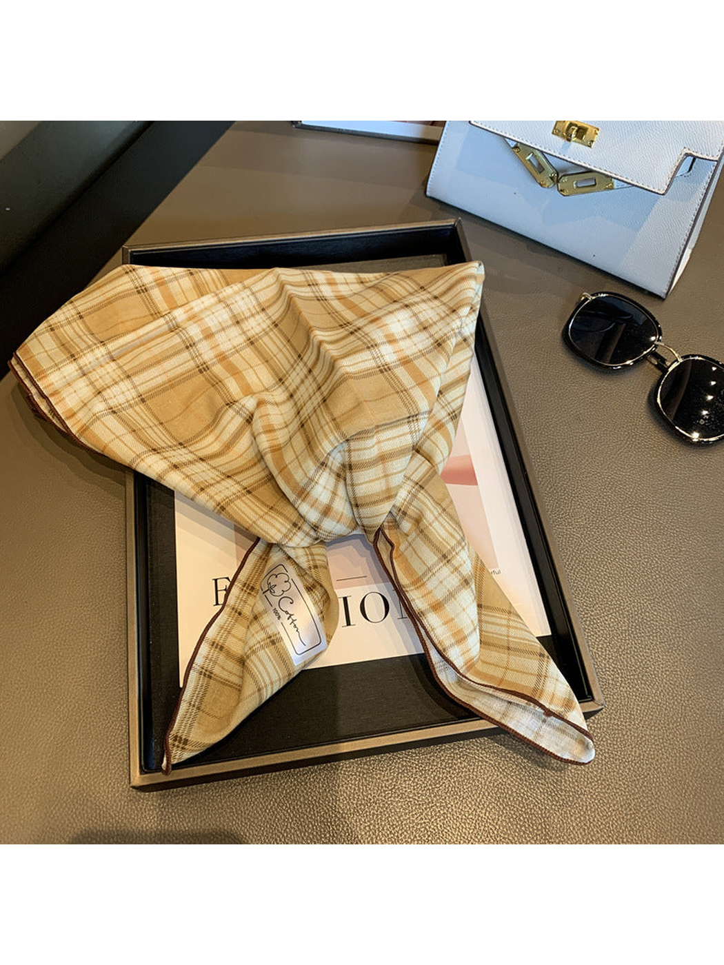 Beige plaid scarf unfolded to show its contrasting stitched edge