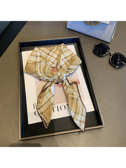 Beige plaid scarf tied in a loose knot with brown edging