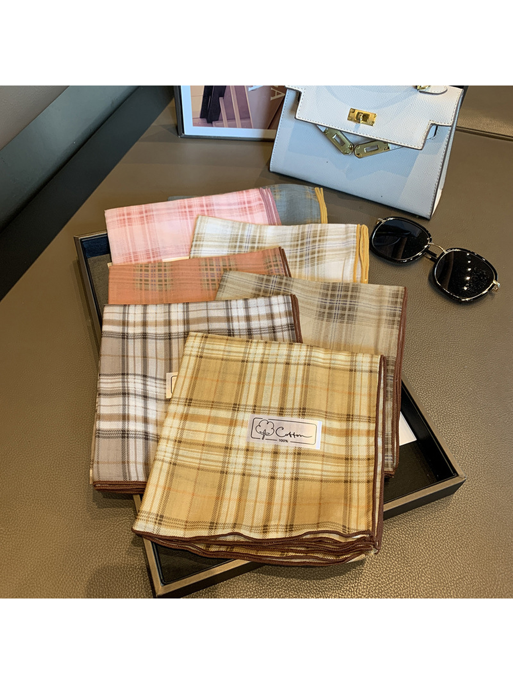 Multiple plaid scarf colors arranged together with contrasting edges visible