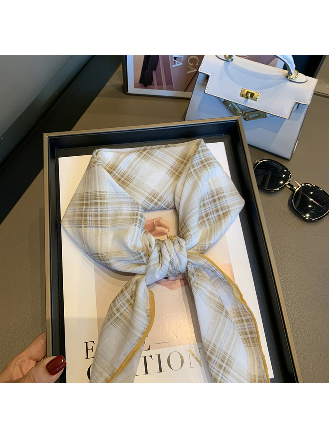 Close-up of the Ivory plaid scarf pattern and golden stitched edge