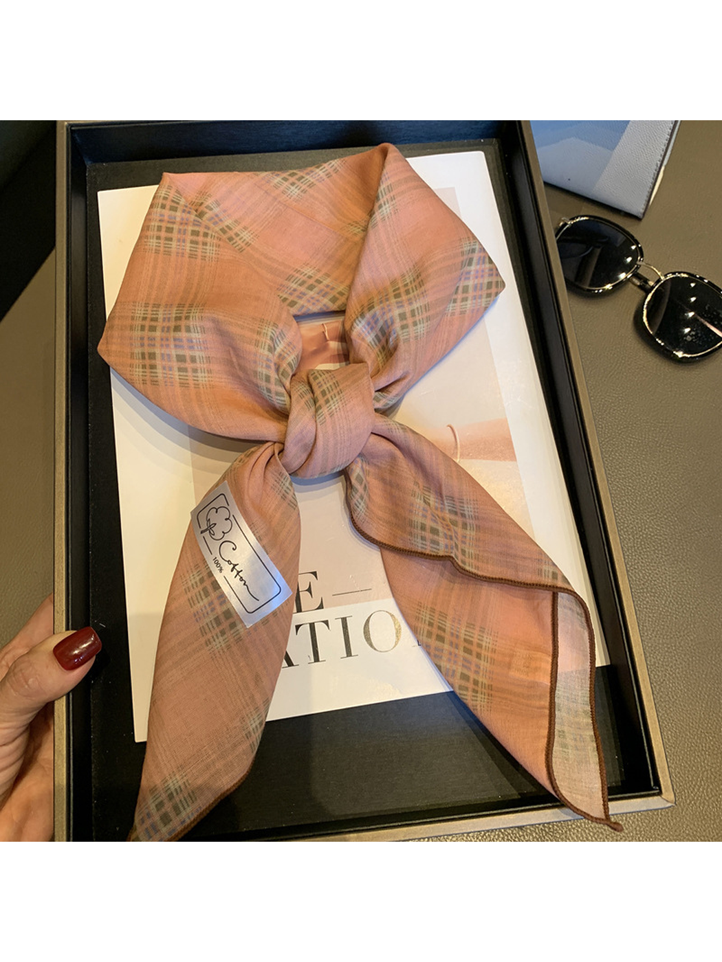 Close-up of the Dusty Pink check pattern, knot and brown stitched edge