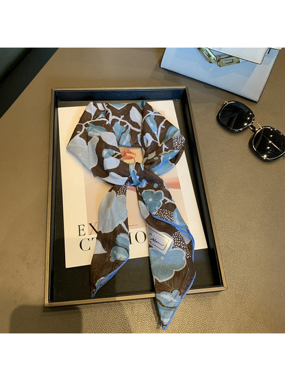 Coffee floral square scarf tied in a loose knot on a display tray