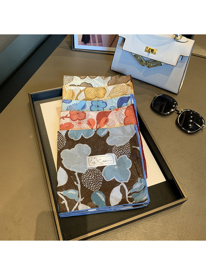 Five floral square scarf colors folded and stacked on a display tray