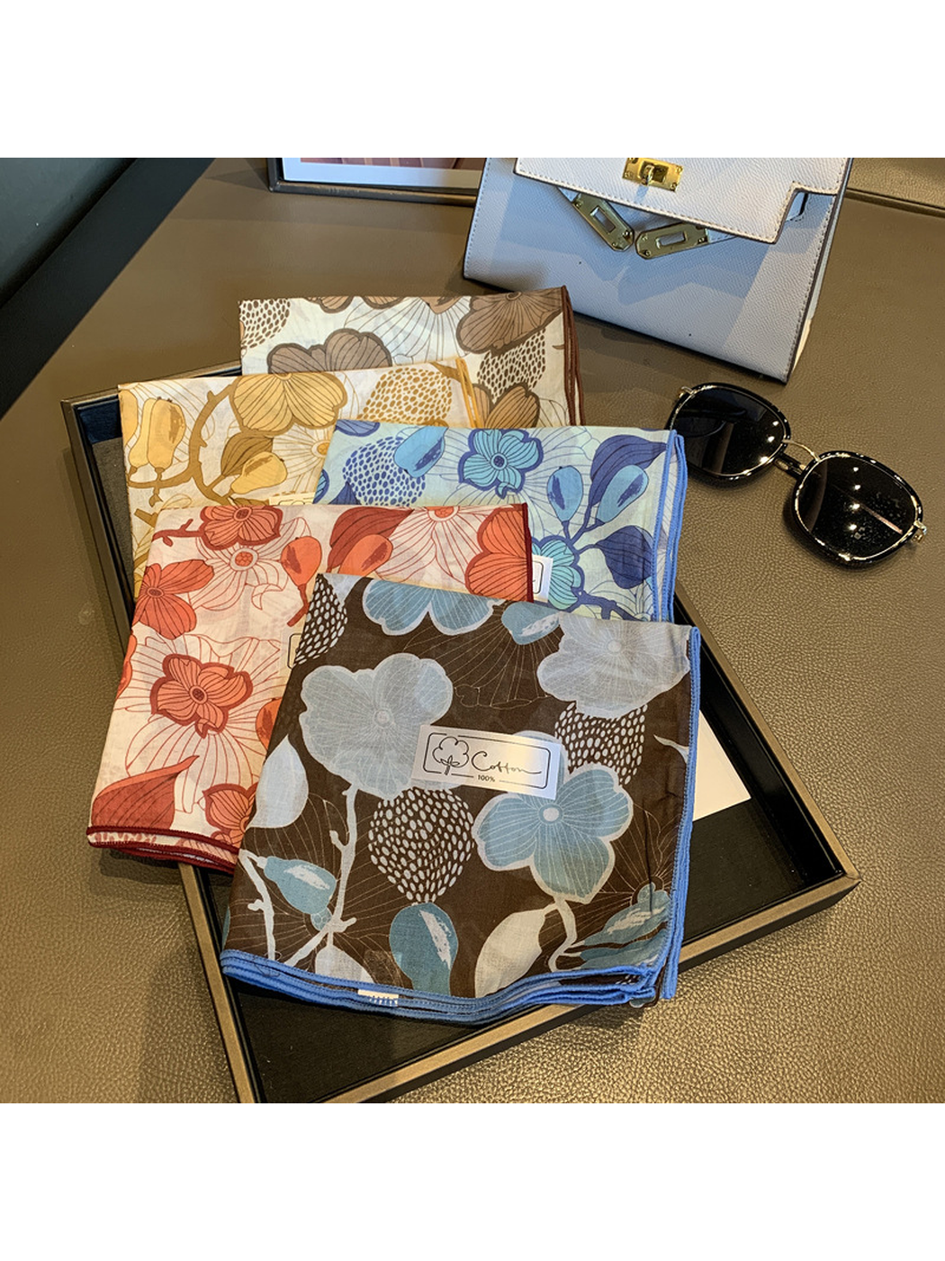 Five floral square scarf colors displayed together with contrast edges visible