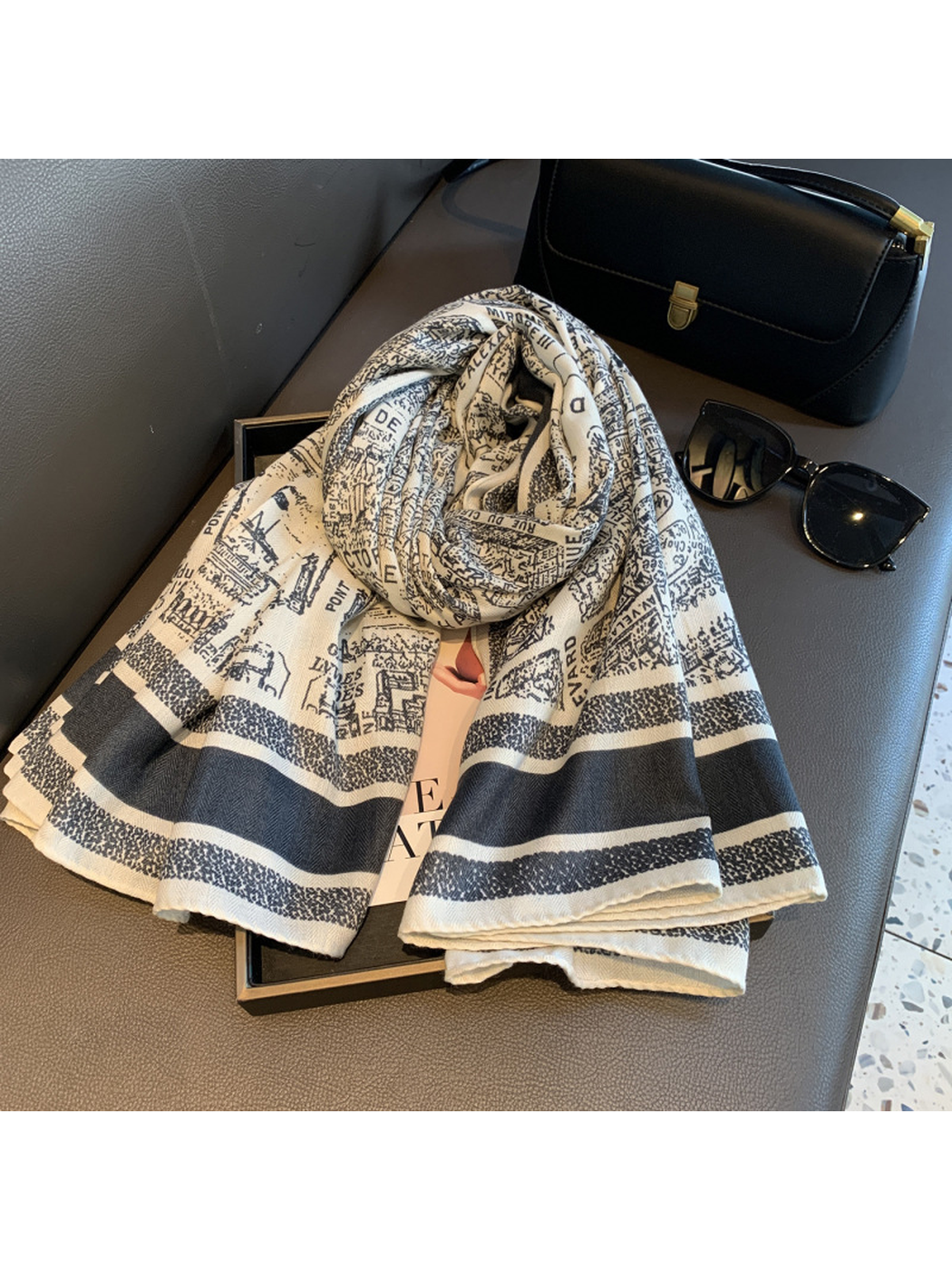 Ivory and navy city map print scarf loosely rolled with its striped ends displayed