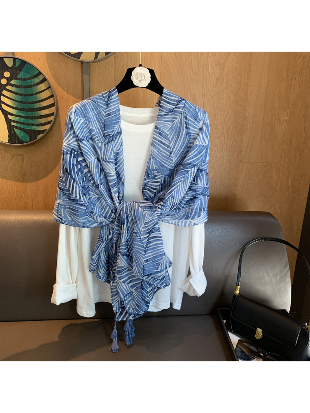 Blue leaf-pattern scarf tied over a white shirt display