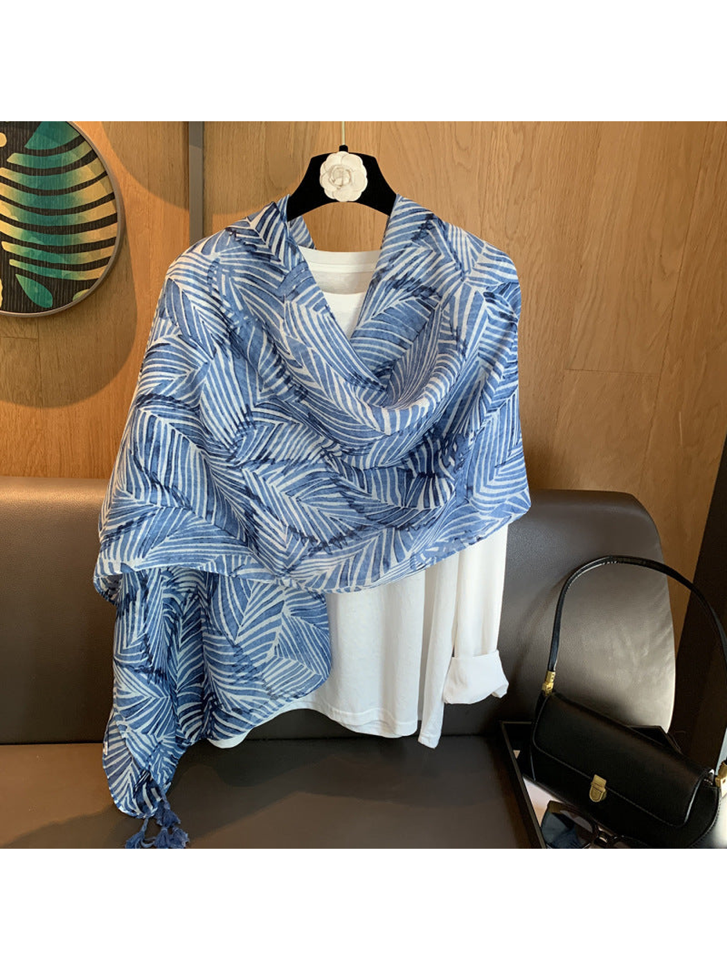 Blue leaf-pattern scarf wrapped across a white shirt display
