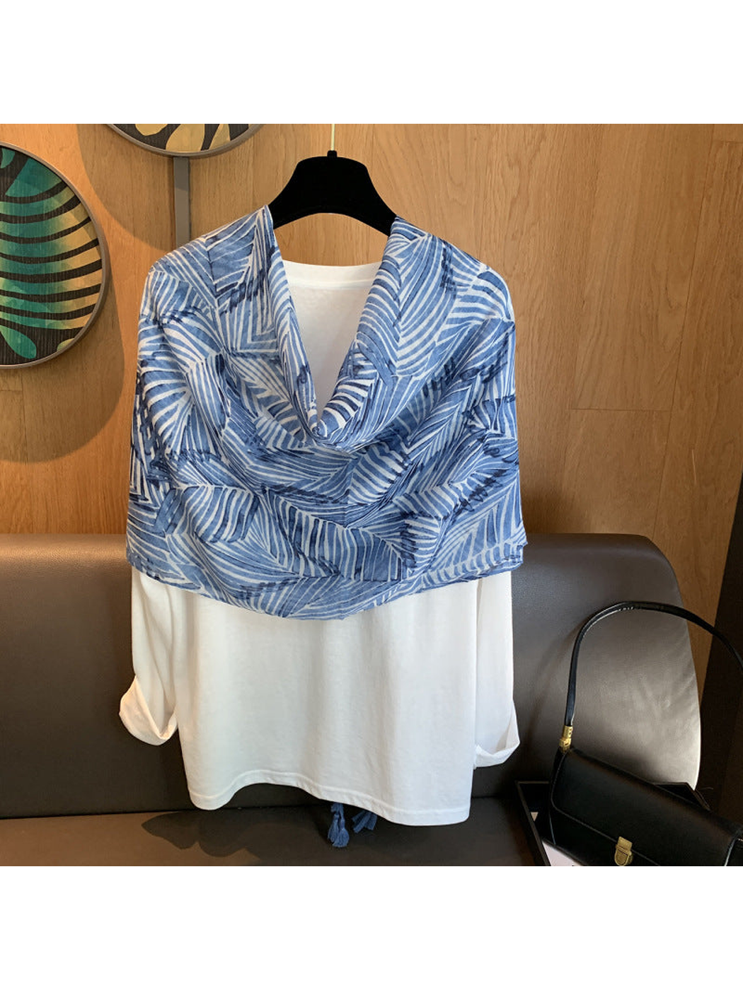 Blue leaf-pattern scarf styled as a loop over a white shirt display