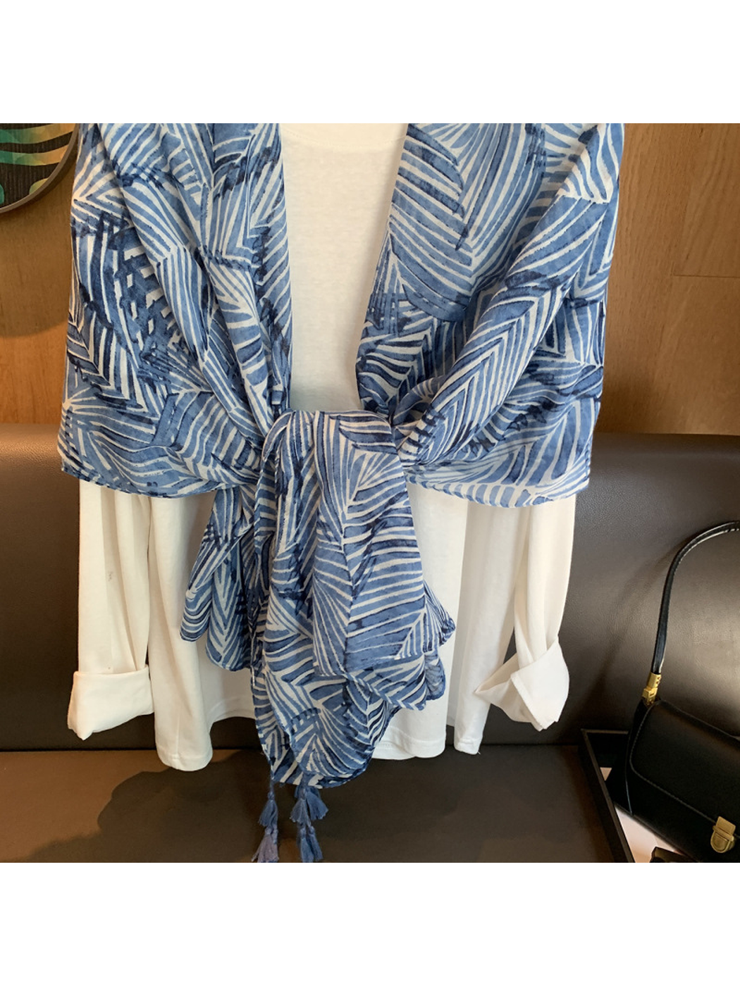 Close-up of the tied blue leaf-pattern scarf and corner tassels