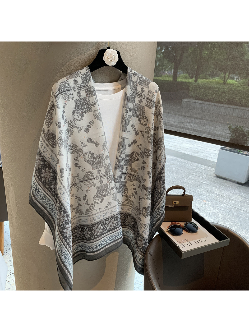 Gray and ivory geometric scarf draped over a white top