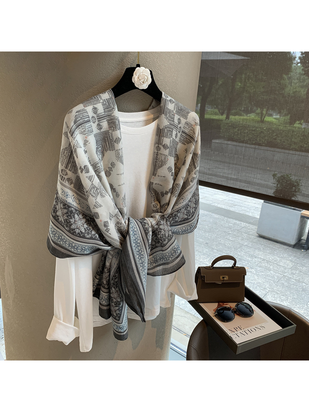 Gray and ivory geometric scarf tied over a white top