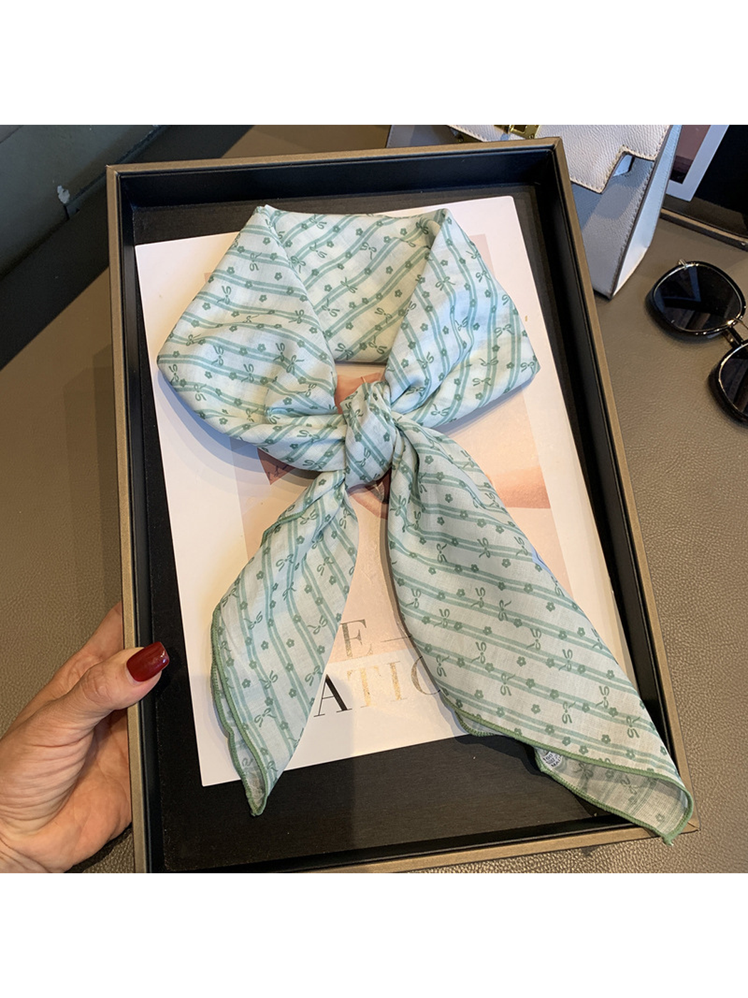 Close view of the Beige Green scarf's striped bow pattern and finished edge