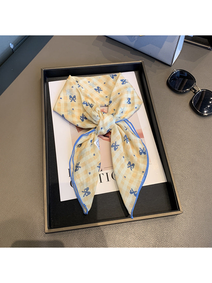 Yellow gingham scarf with blue bow motifs, tied view