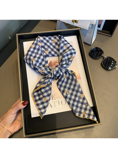Navy Orange gingham scarf with bow motifs tied and held in a tray