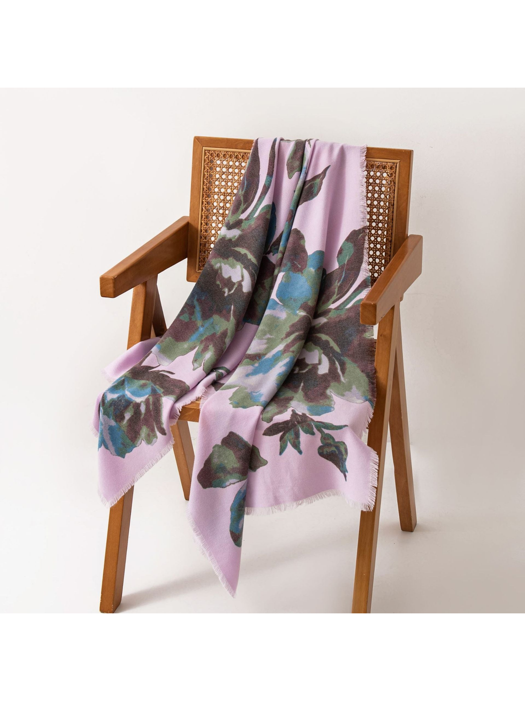 Purple floral scarf draped over a cane-back wooden chair