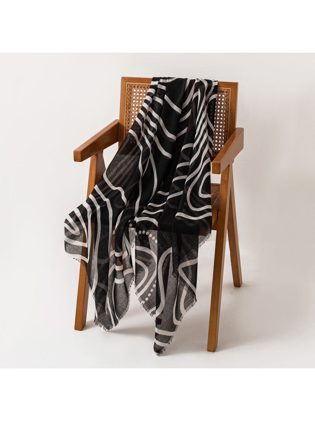 Black scarf with abstract white contour pattern draped over a chair