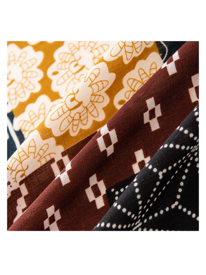 Close-up of the scarf's mustard, brown and black printed texture