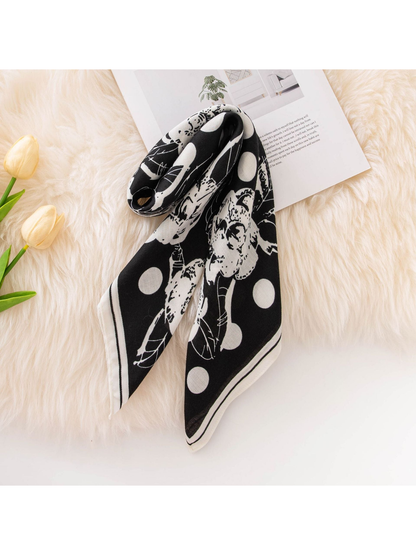 Black floral and polka dot square scarf loosely looped with pointed ends