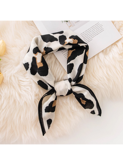 Black, tan and ivory cow print square scarf styled in a loose knot