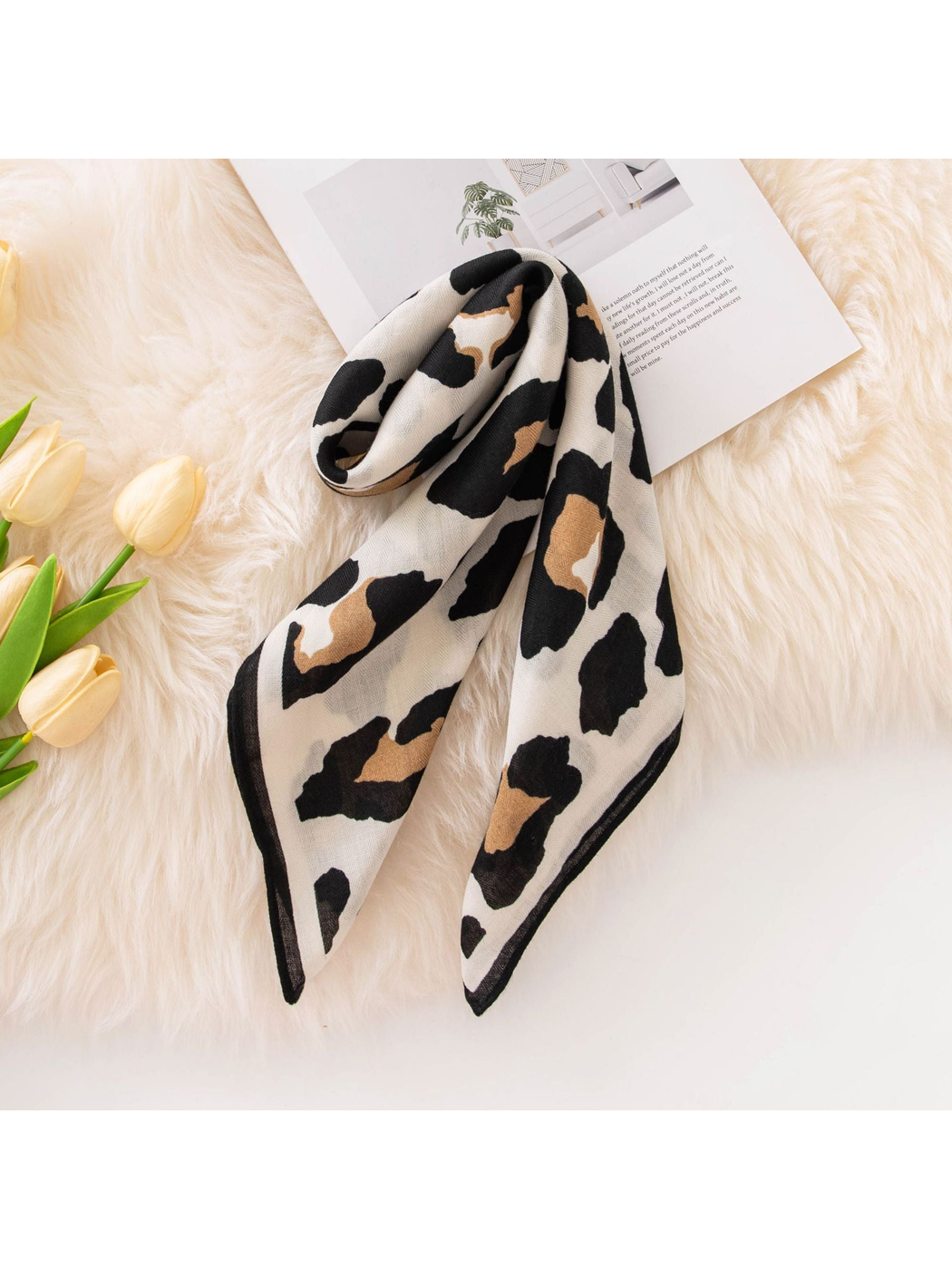 Black, tan and ivory cow print square scarf arranged in a long drape