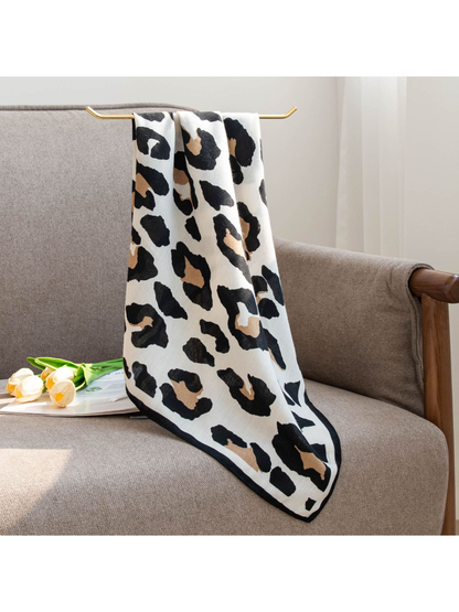 Black, tan and ivory cow print square scarf hanging over a chair