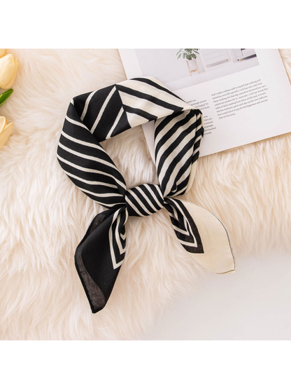 Black and ivory geometric striped square scarf tied in a compact knot