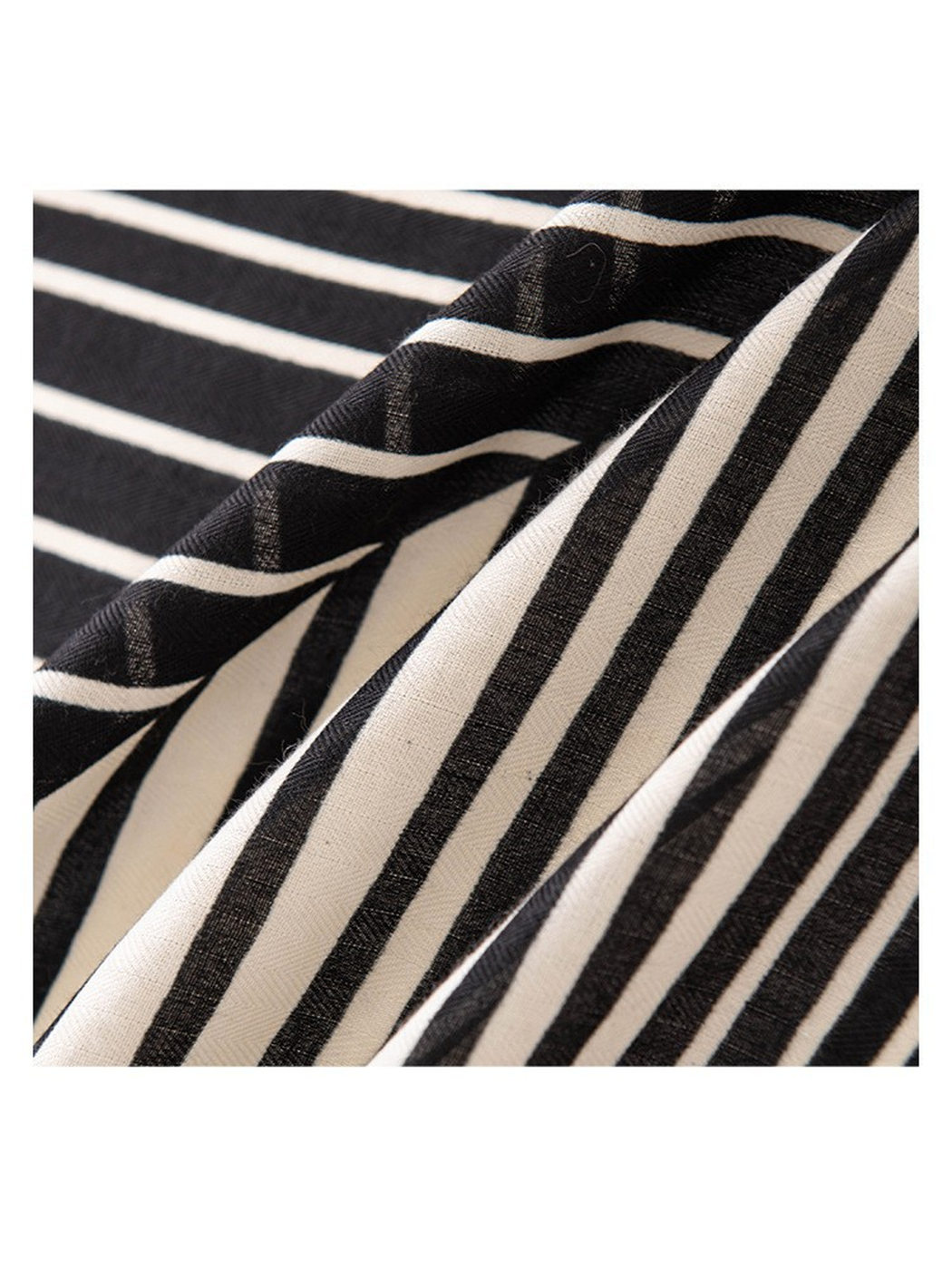 Close-up of the black and ivory striped scarf's fine diagonal weave texture