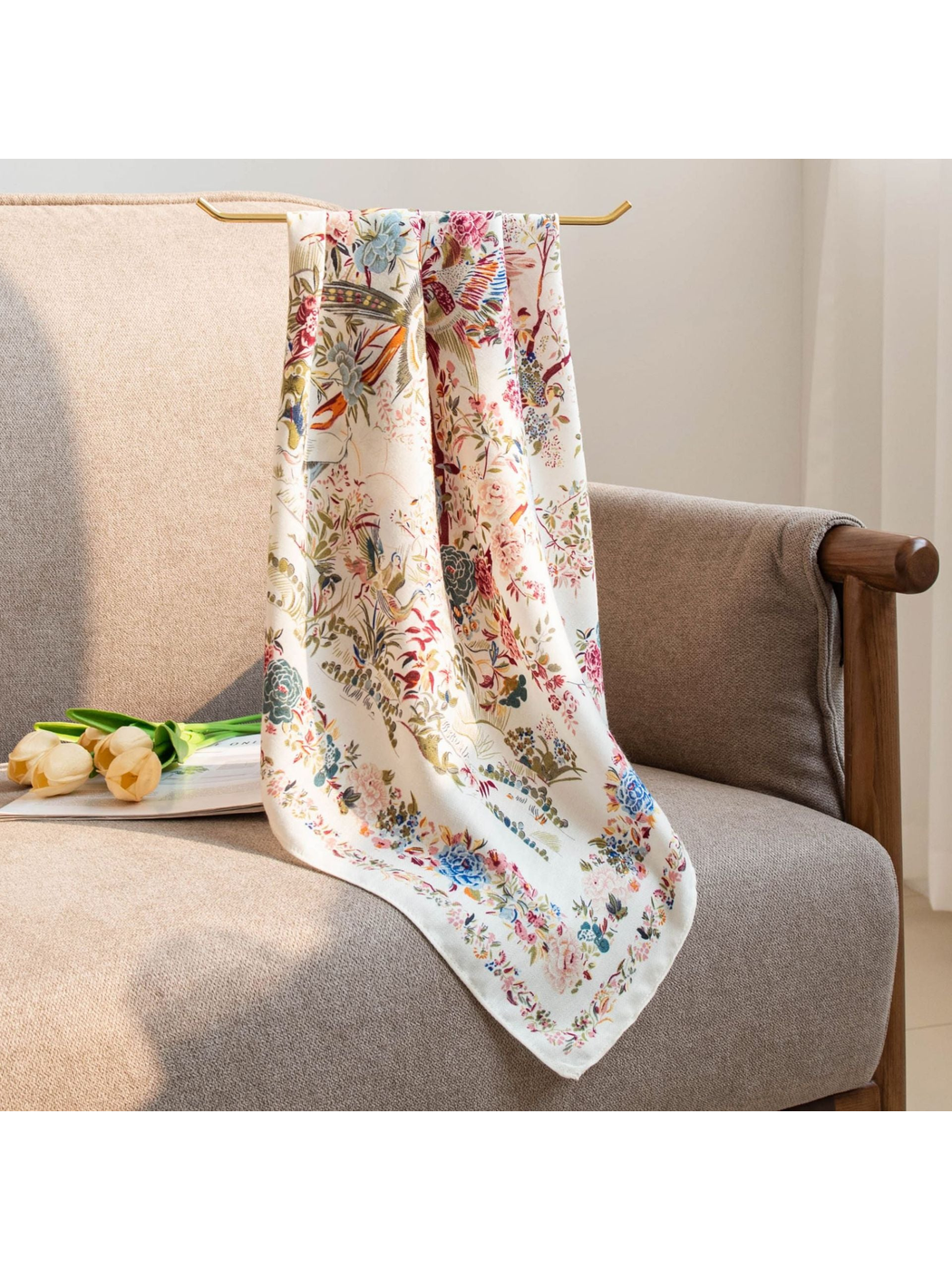 Ivory bird-and-floral square scarf draped over a neutral armchair