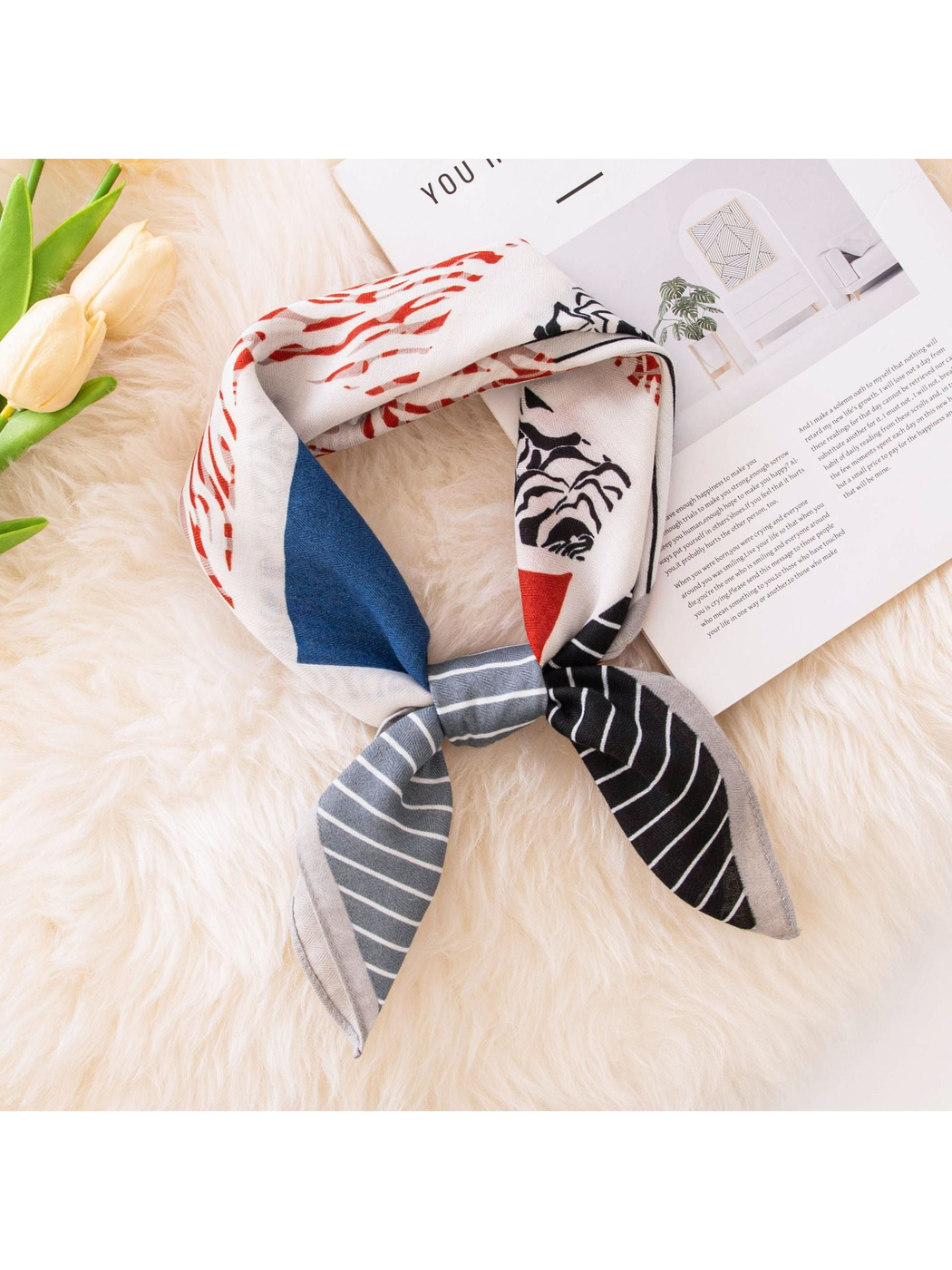 Multicolor square scarf tied on a light textured surface with tulip accents