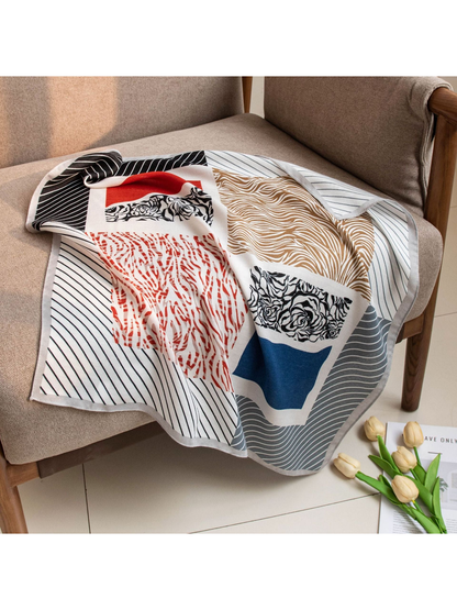 Multicolor patchwork square scarf draped across a neutral armchair