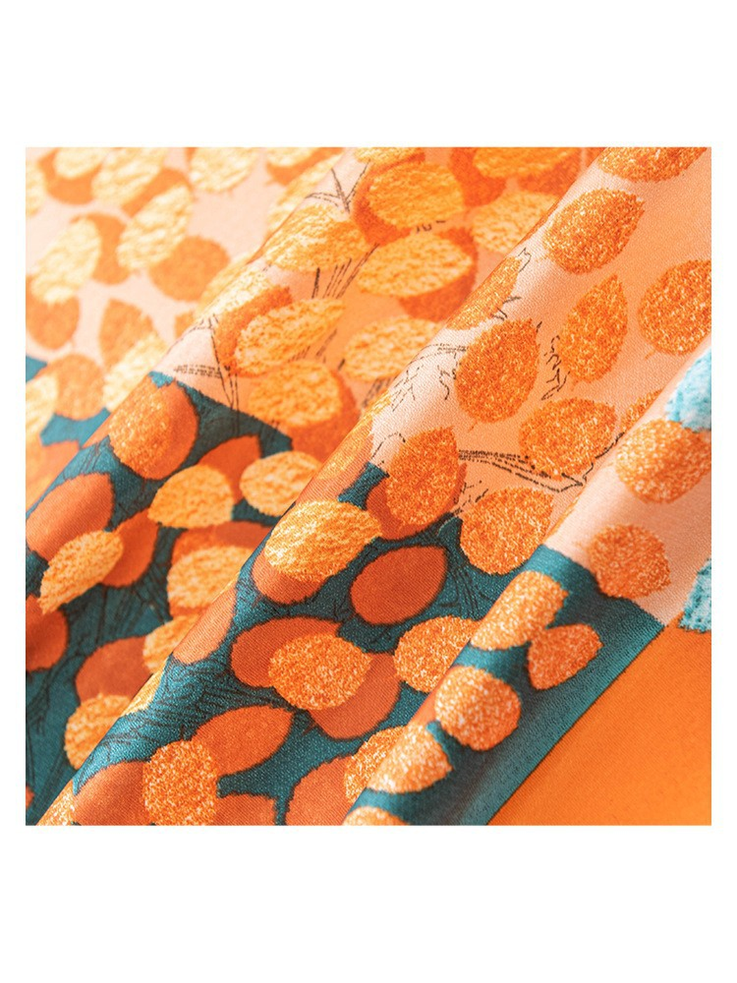 Close-up of the scarf's orange and teal leaf pattern and lustrous surface