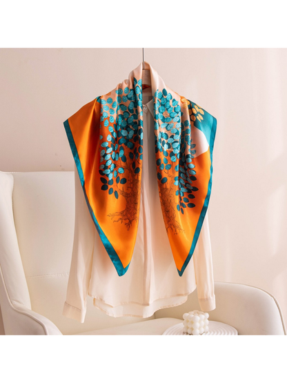 Orange and teal patterned square scarf displayed over a white blouse