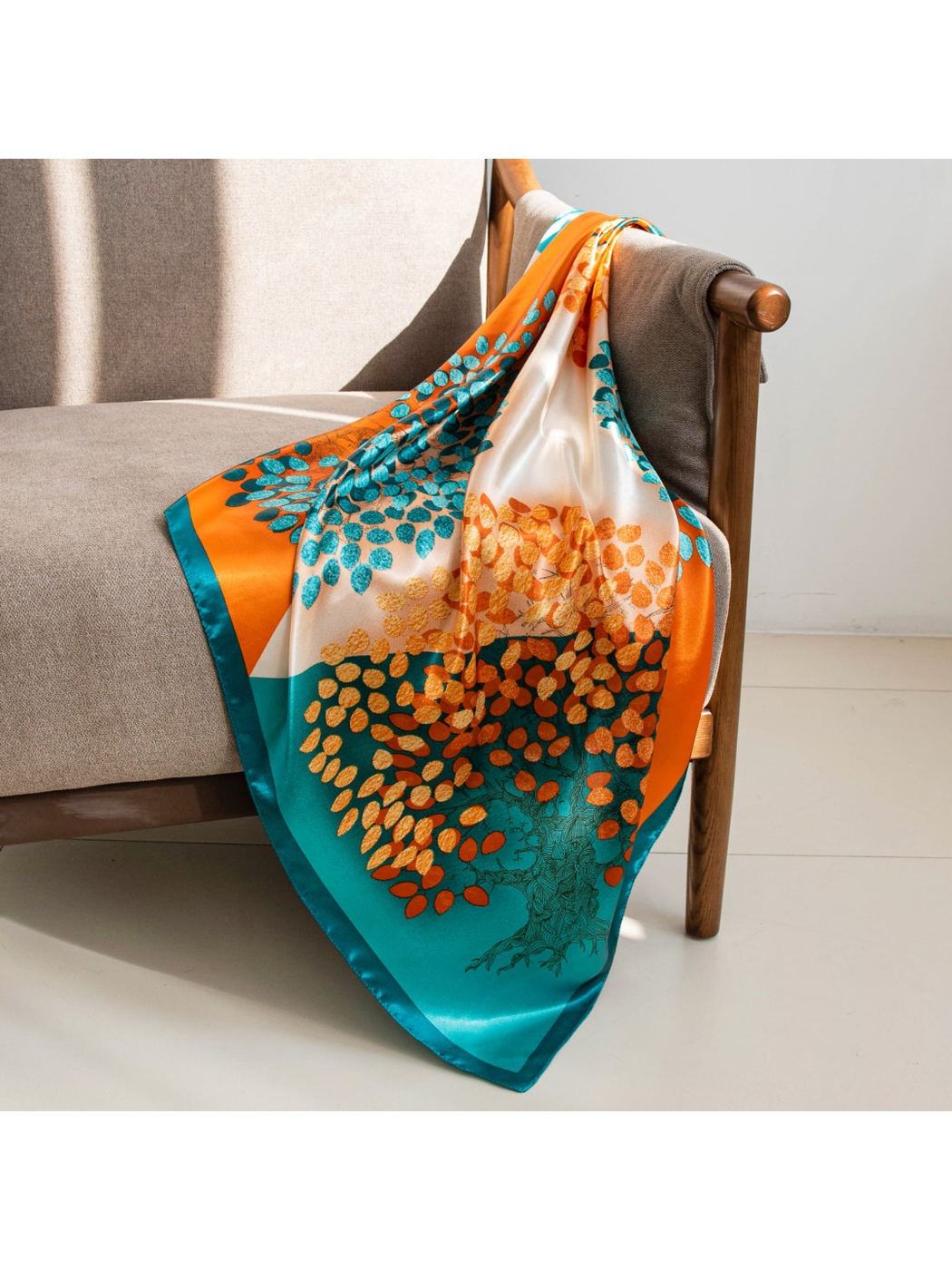 Orange, cream and teal square scarf draped over an armchair