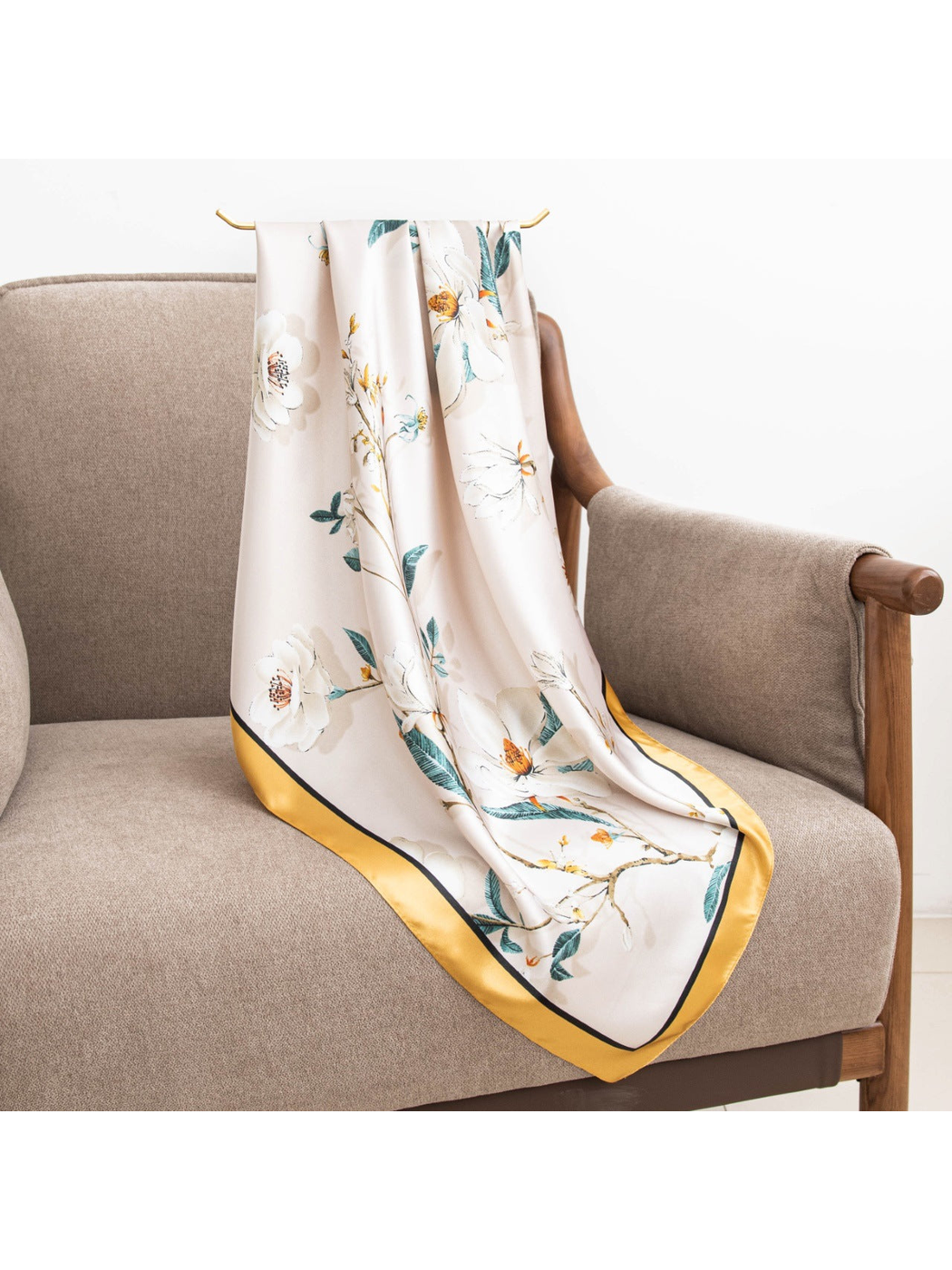 Blush floral square scarf with gold border draped across an armchair