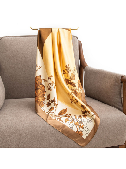 Orange, yellow, cream and brown botanical scarf draped over an armchair